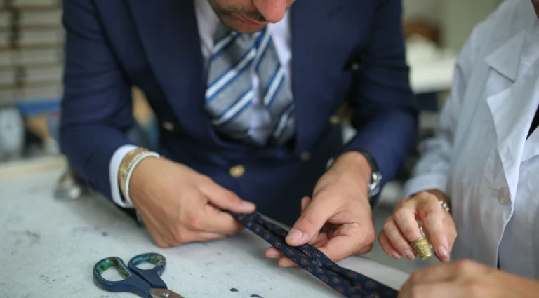 A client and an artisan checking a fabric together in an Italian workshop