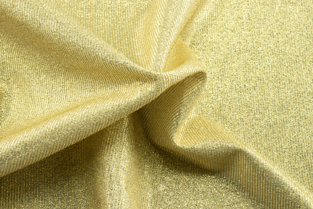 Golden fabric that looks smooth to the touch and shiny.