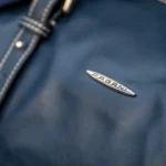 Navy technical fabric bag with contrast stitching and metal logo plate