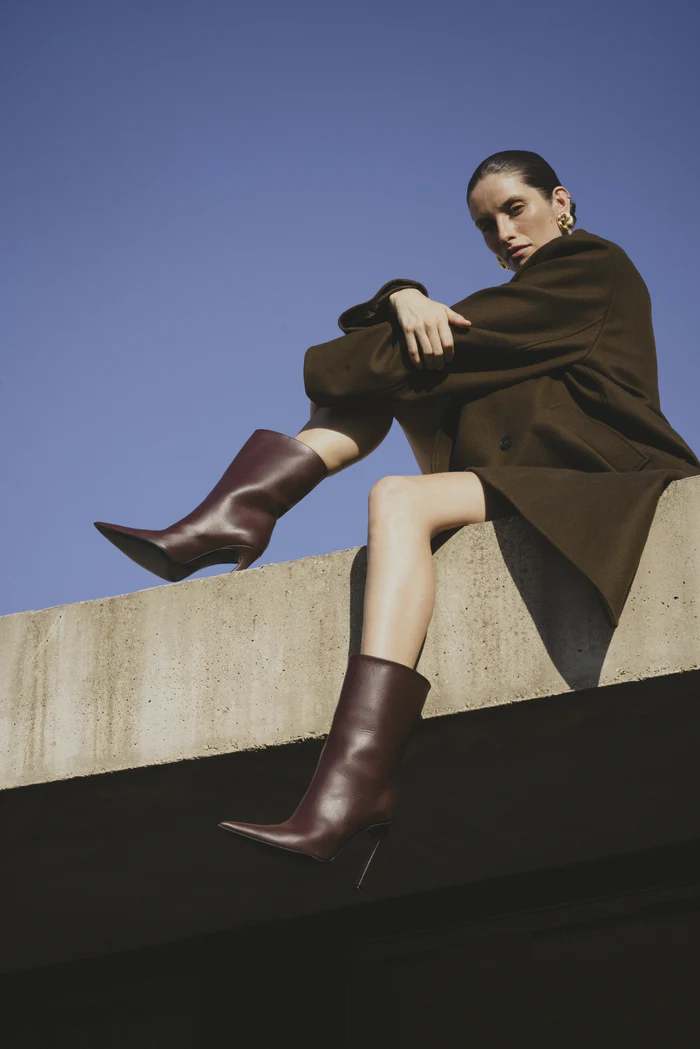 Hagelstam burgundy leather boots worn by a model on a concrete wall, made in Italy with Italian Artisan