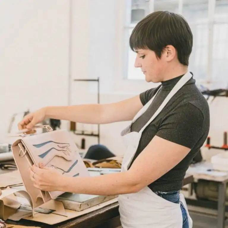 Craftswoman working on a bag pattern in an Italian workshop