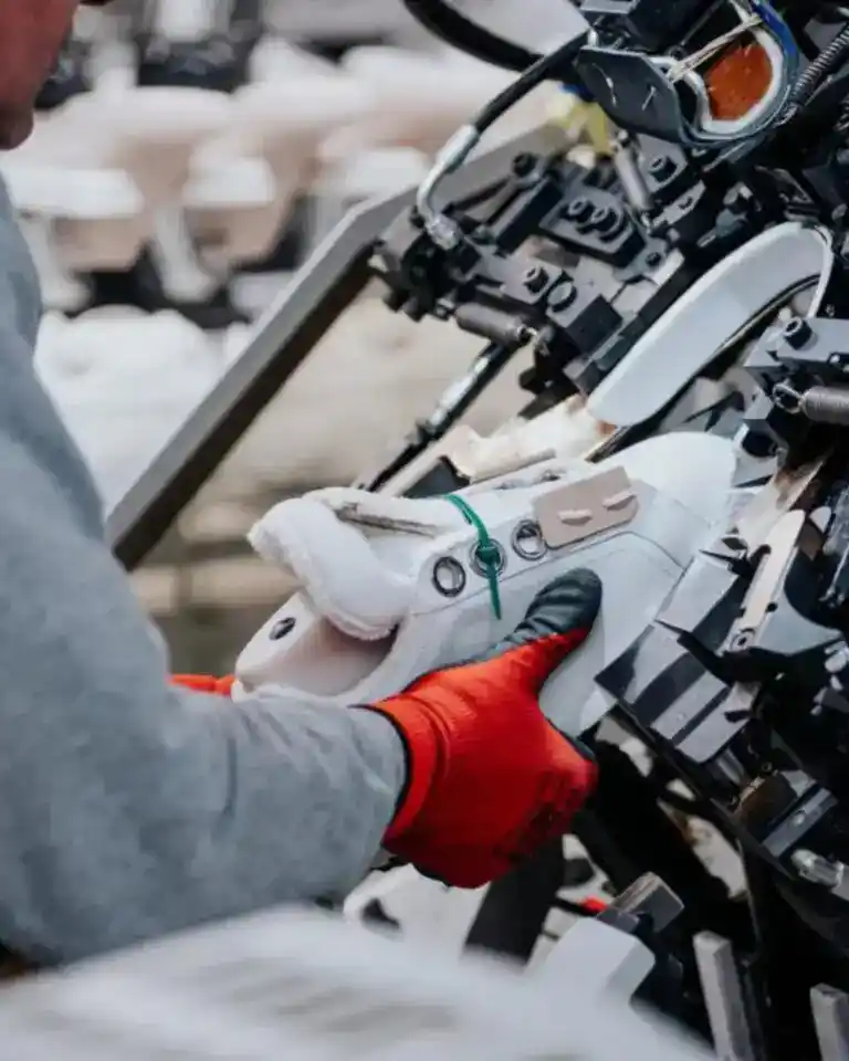 An artisan lasts an upper on a lasting machine in an Italian shoe factory