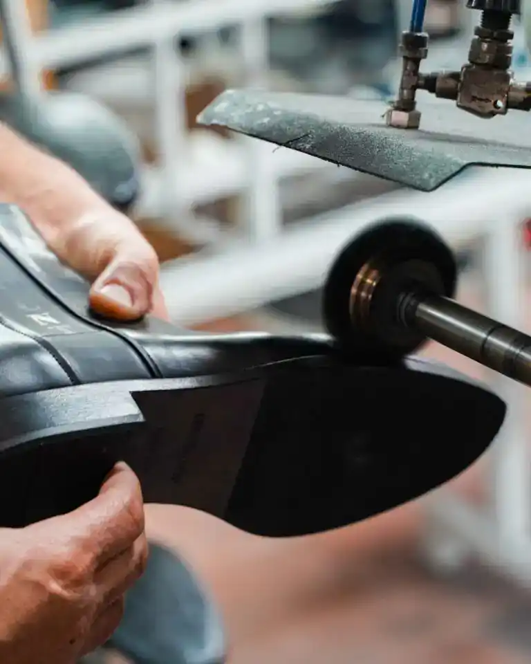Pressing a leather sole onto a shoe in an Italian footwear workshop