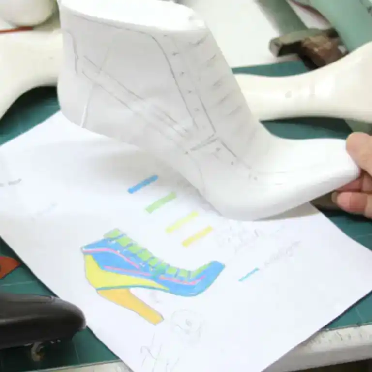 A shoe last marked up next to a design sketch during prototyping