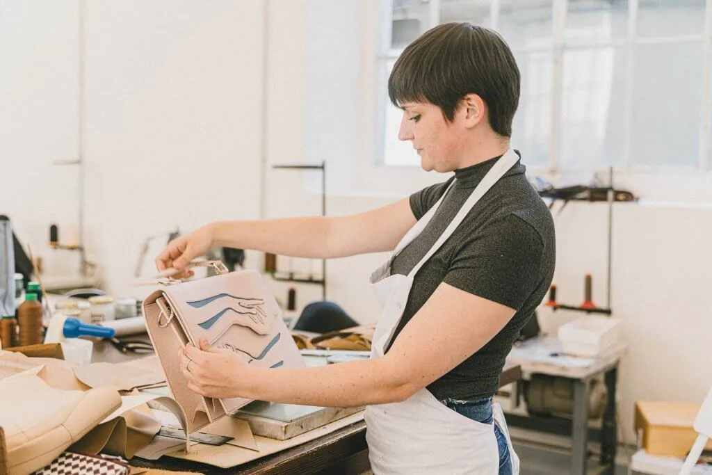 An artisan sewing in an Italian clothing workshop