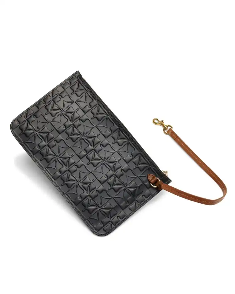 Maison Veni Sarah clutch with an embossed pattern and a tan wrist strap, made in Italy