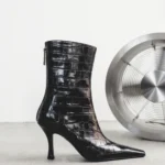 Crocodile-embossed black leather ankle boot with a sculpted heel