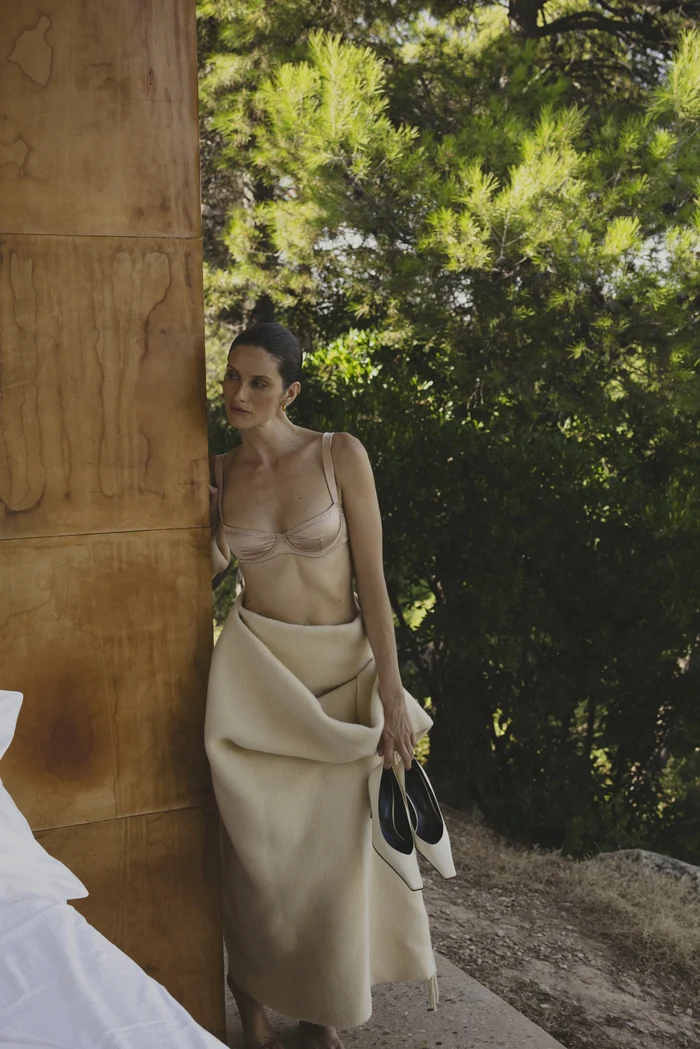 Hagelstam campaign: a model leans against a tree holding a pair of cream pumps