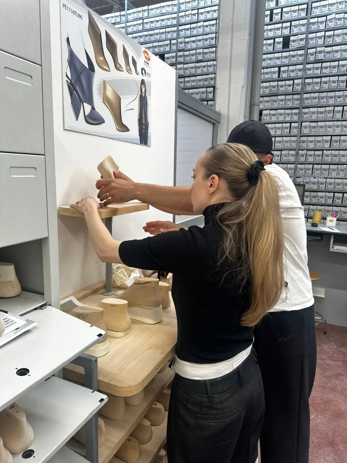 Sandra Hagelstam and an artisan review heel shapes in front of a mood board of shoe sketches