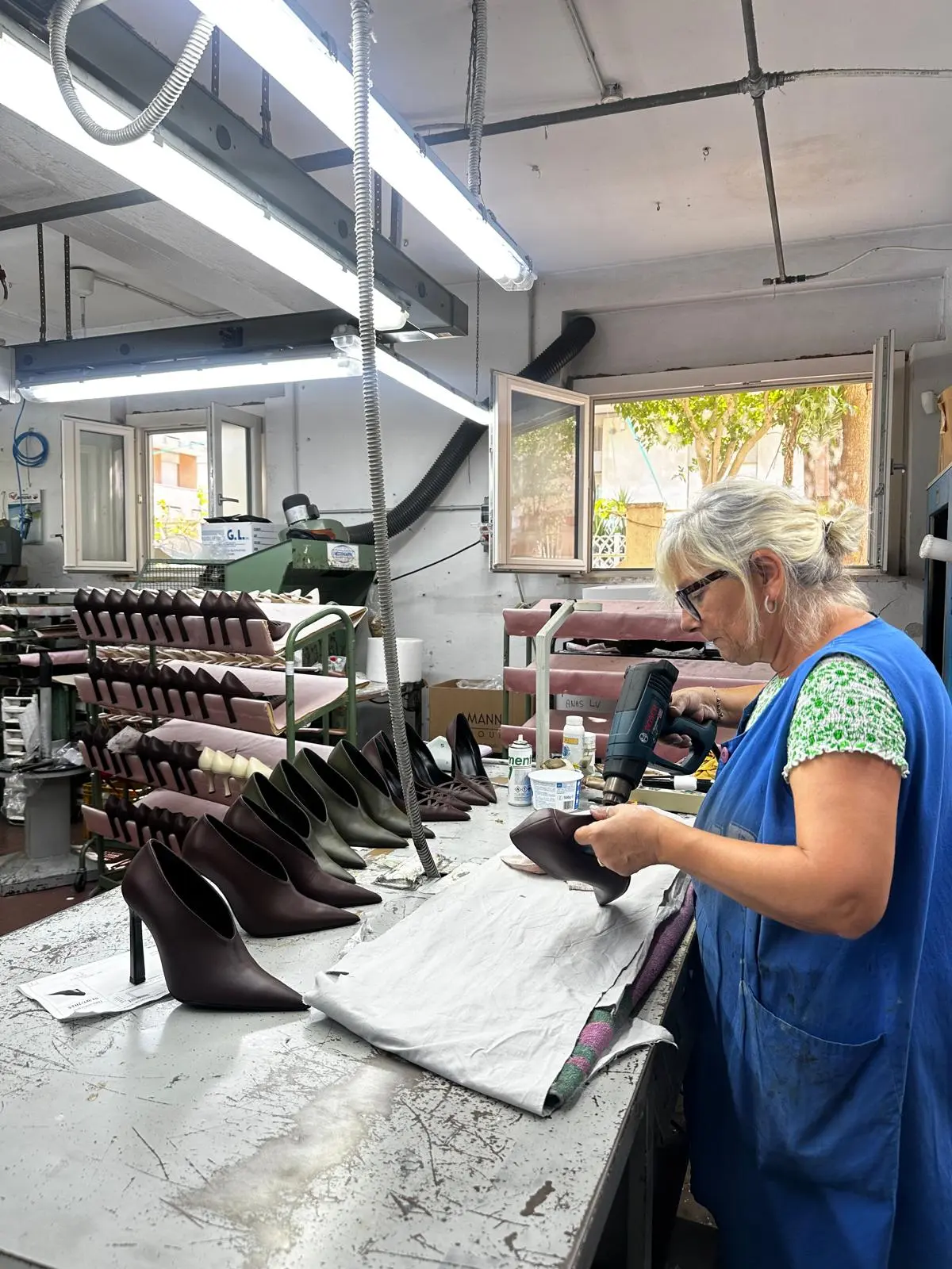 A row of finished brown pumps on the factory bench before final inspection