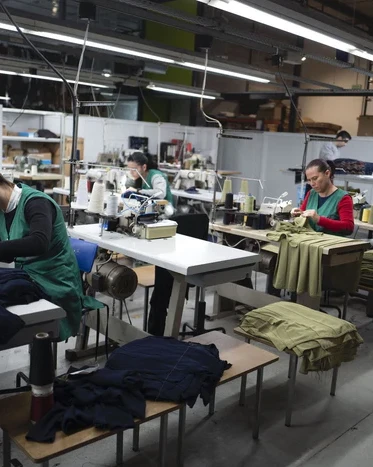 Machinists sewing garments in an Italian apparel workshop