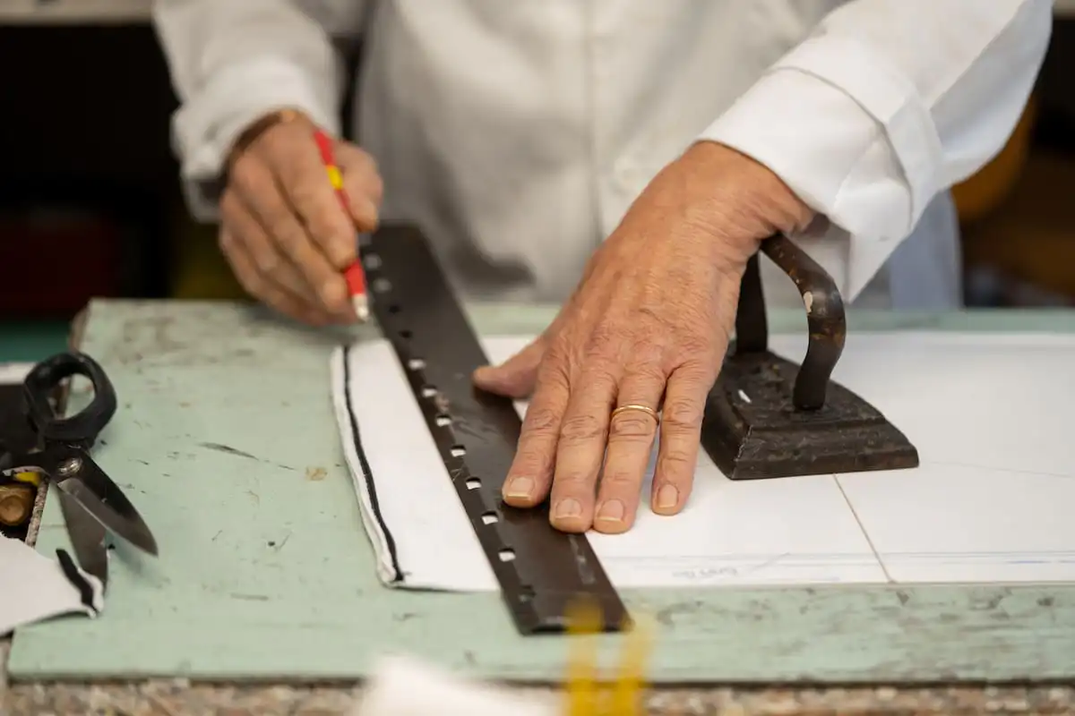 An artisan ruling a pattern on the cutting board of an Italian workshop